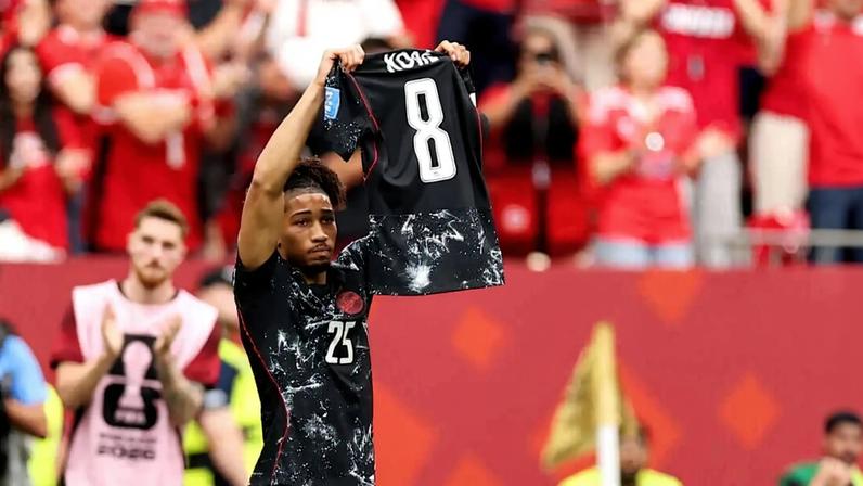 Nathan Saliba holds up injured Ismael Kone's shirt after scoring Canada's fourth goal against Qatar