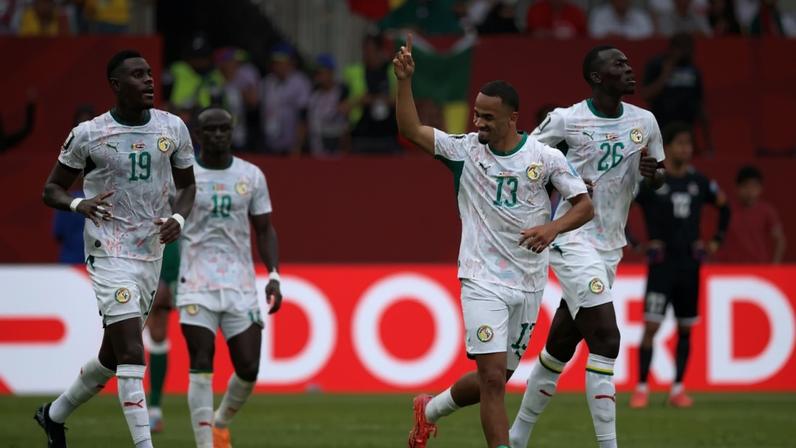 Iliman Ndiaye celebrates with team-mates after scoring his team's fifth against Iraq