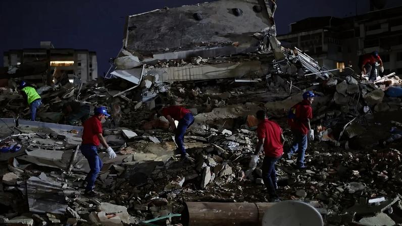 Equipes de resgate buscam vítimas em um prédio destruído no bairro de San Bernardino, em Caracas, Venezuela, após um terremoto de magnitude 7,2 atingir o país e outras regiões do Caribe. 24/06/2026 - (Jesus Vargas/Getty Images)