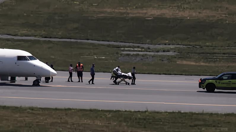 Comandante é retirado de maca da aeronave pelo serviço de resgate