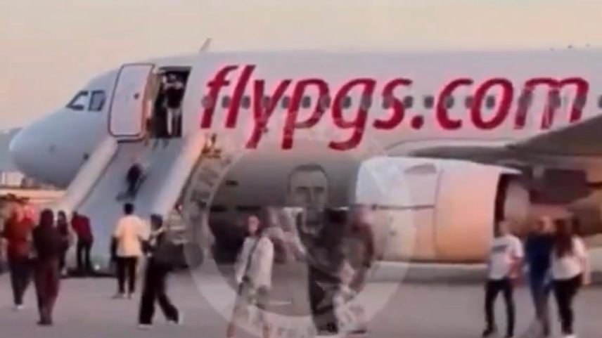Passageiros deixam a aeronave por escorregadeiras infláveis