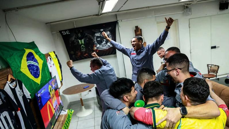 Bombeiros da Polícia Militar de São Paulo comemoram o segundo gol da seleção brasileira no batalhão da Sé, região central