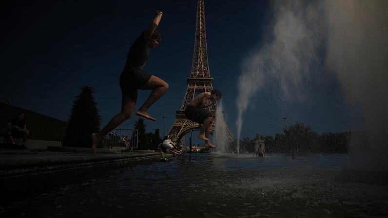 Pessoas pulam na Fonte do Trocadero, perto da Torre Eiffel, durante uma onda de calor em Paris.