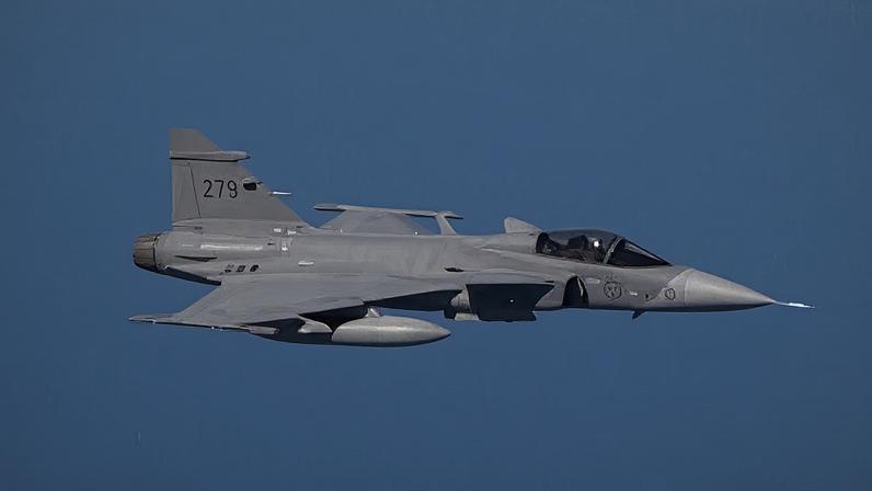 Um caça Gripen voa pelos céus em alta velocidade.