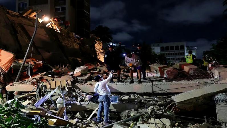 Equipes de emergência trabalham no local de um prédio que desabou após um terremoto em Caracas