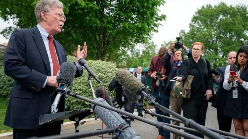 Bolton (à dir.) havia se declarado inocente em outubro de 2025; para a Justiça norte-americana, ele “abusou de sua posição oficial” ao expor documentos confidenciais a familiares