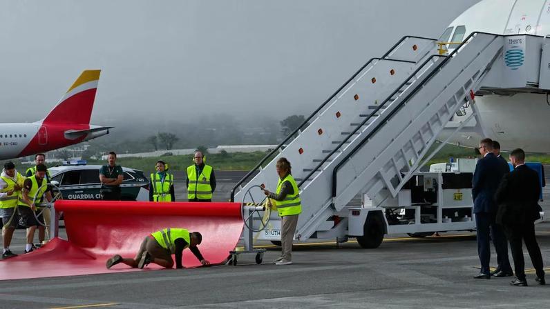 Trabalhadores estendem o tapete vermelho enquanto o avião que transporta o papa Leão XIV chega ao Aeroporto Internacional de Los Rodeos, na ilha canária de Tenerife, em 12 de junho de 2026.