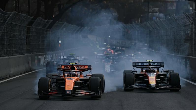 O piloto britânico da McLaren, Lando Norris (à esquerda), trava as rodas ao liderar a corrida à frente do piloto monegasco da Ferrari, Charles Leclerc (à direita), na primeira curva durante o Grande Prêmio de Mônaco de Fórmula 1, no Circuito de Mônaco (Foto: Andrej Isakovic / Afp)