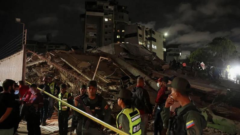Membros da Guarda Nacional Bolivariana montam guarda no local de um prédio desabado que foi isolado após um terremoto em Caracas, Venezuela, em 24 de junho de 2026.
