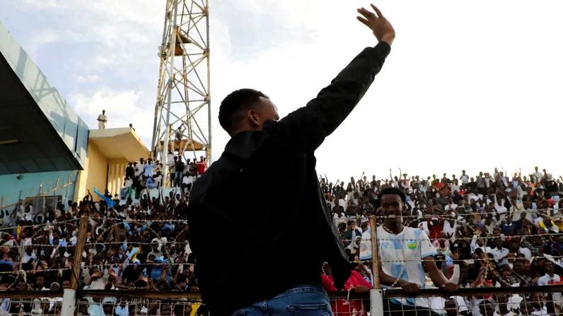 O árbitro somali Omar Abdulkadir Artan, barrado nos Estados Unidos antes da Copa do Mundo, acena para os torcedores no estádio de Mogadíscio, na Somália - 10/06/2026 (Foto: REUTERS/Feisal Omar/TPX IMAGES OF THE DAY)