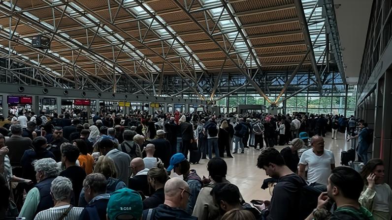 Pessoas reunidas em um saguão no Aeroporto de Hamburgo, na Alemanha, devido a uma situação policial no local. A área de segurança do aeroporto foi esvaziada