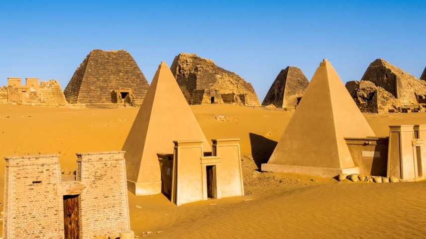 Conjunto de pirâmides núbias com paredes inclinadas construídas em arenito vermelho no deserto – Créditos: depositphotos.com / katiekk