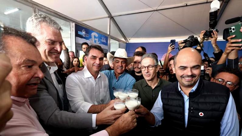 Flávio e Zema brindam com copo de leite durante evento em Belo Horizonte ao lado do governador Mateus Simões (de colete)