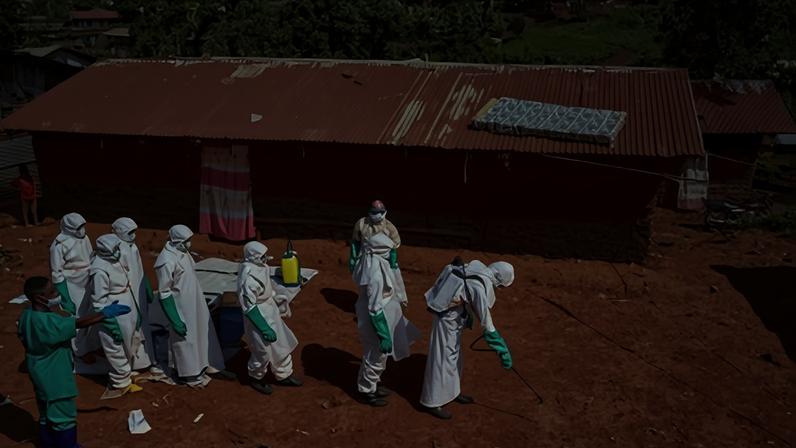 Trabalhadores da Cruz Vermelha desinfetam chão do lado de fora da casa de um homem não identificado que morreu de Ebola, em Mongbwalu, Território Djugu da província de Ituri, República Democrática do Congo