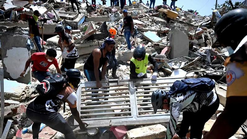 Voluntários procuram mortos e feridos meio aos escombros de terremotos em La Guaira, na Venezuela