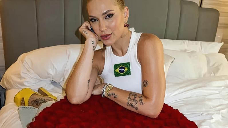 Virgina posa ao lado de buquê de flores e caixa de joia