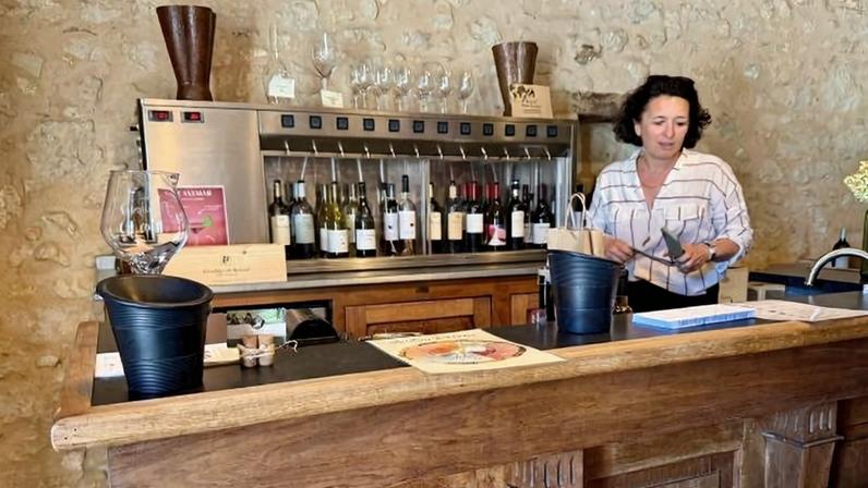 Sylvie Courselle serves wines by the glass at the in the winery of Château Thieuley