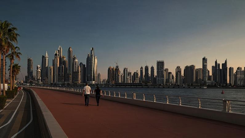 Um casal caminha por um calçadão em Palm Jumeirah, em Dubai, Emirados Árabes Unidos