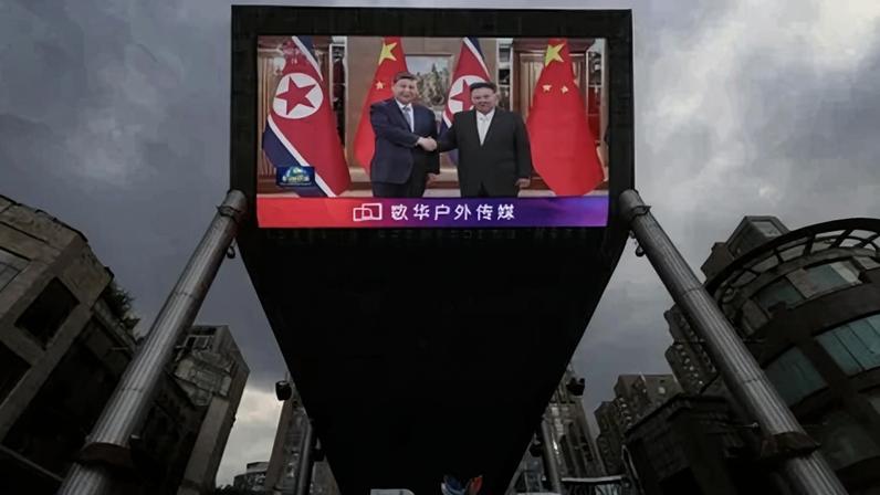 Tela gigante em uma área de compras em Pequim mostra imagens do presidente chinês, Xi Jinping, visitando a Coreia do Norte - 8 de junho de 2026