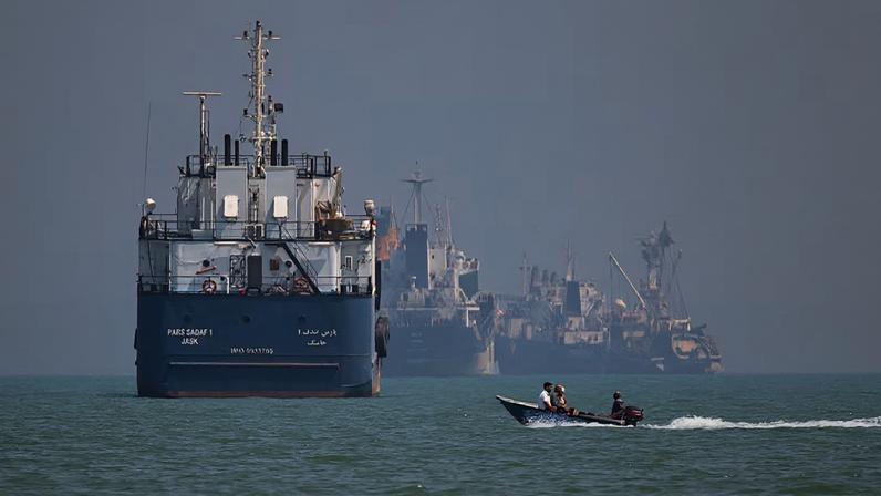 Uma pequena embarcação passa diante de navios ancorados no Estreito de Ormuz, próximo a Bandar Abbas, no Irã, na quinta-feira, 11 de junho de 2026. Foto: Amirhosein Khorgooi/ISNA via AP