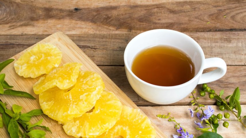 Bebidas herbais saudáveis, chá quente com abacaxi, sobremesa de frutas secas, lanche saboroso e estilo de vida relaxante. Arranjo no estilo flat lay sobre fundo de madeira. Foto: phenphayom - stock.adobe.com/Adobe st