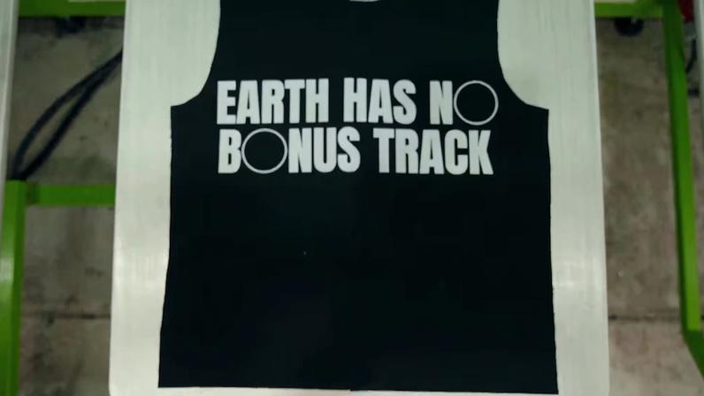 Camiseta preta reutilizada com a frase “Earth Has No Bonus Track” estampada em branco