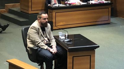 Leniel Borel durante depoimento com Monique Medeiros ao fundo