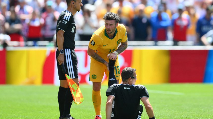 Felix Zwayer, árbitro de Estados Unidos x Austrália recebe ajuda de jogador no gramado após sofrer com cãibras