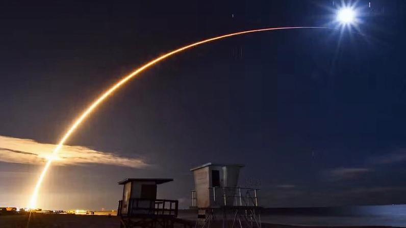 foguete Falcon 9, da SpaceX, é visto cruzando o céu em direção à lua minguante