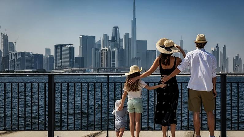 iStock / Getty Images A family of four looking across the water at the Dubai skyline