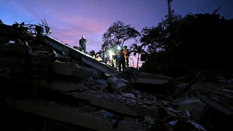 Voluntários e bombeiros equatorianos da Busca e Resgate Urbano (USAR) procuram corpos no local de um prédio que desabou em Caraballeda, estado de La Guaira. — Foto: Juan Barreto / AFP