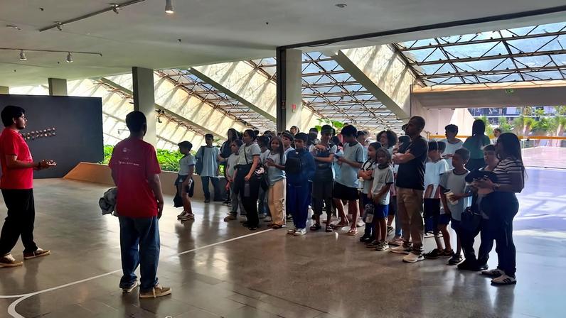 Foto colorida de estudantes em visita a mostra Constelações Contemporâneas