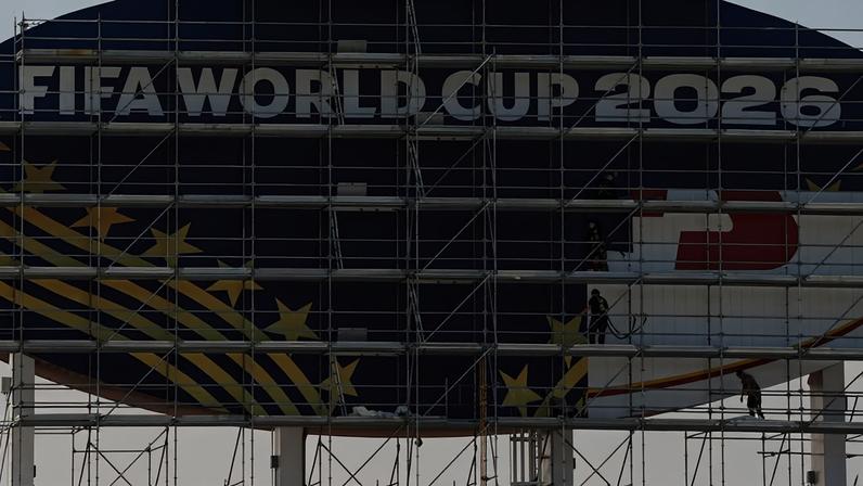 Operários cobrem uma placa do Kansas City Chiefs para a Copa do Mundo da FIFA de 2026 enquanto as obras continuam para transformar o Arrowhead Stadium em Kansas City Stadium, em preparação para o torneio de futebol da Copa do Mundo da FIFA, na segunda-feira, 8 de junho de 2026, em Kansas City, Missouri — Foto: AP/Charlie Riedel