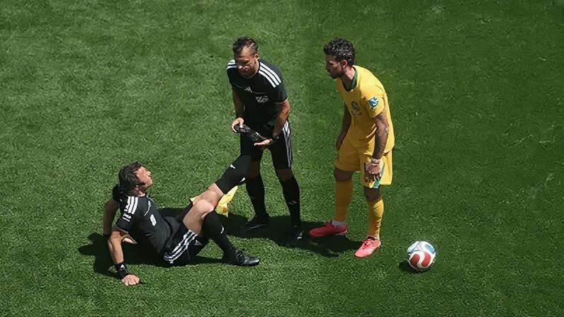 O árbitro Felix Zwayer com câimbras no duelo Estados Unidos x Austrália, pela Copa do Mundo