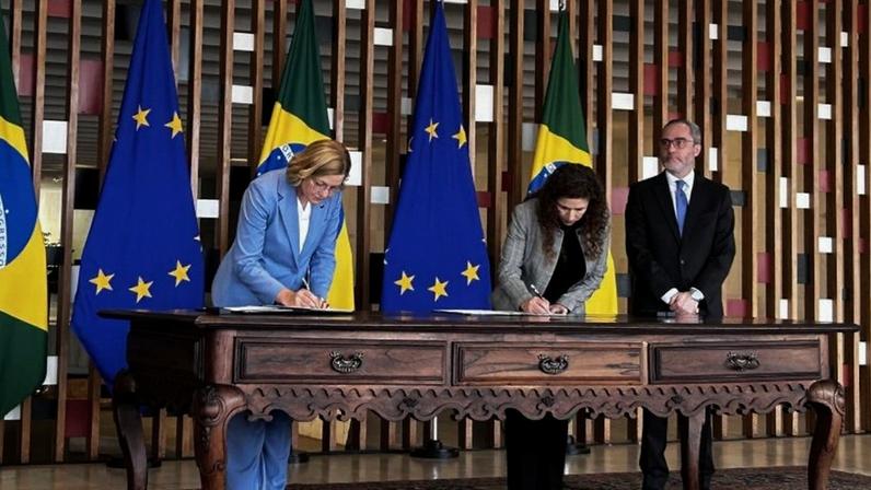 Na imagem, o momento em que Henna Virkkunen (à esq.) e a ministra Esther Dweck (à dir.) assinam o acordo no Itamaraty