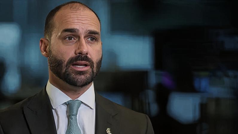Reuters Brazilian lawmaker Eduardo Bolsonaro sits down, wearing a dark suit and blue tie