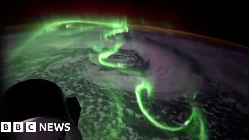 Green southern lights seen above earth from space.
