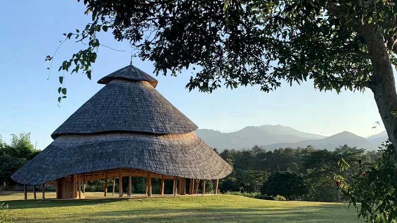 Estrutura em bambu do Bamboo Cathedral, sala de meditação em Chiang Mai que utiliza feixes para formar arcos estruturais e sustentar cobertura leve integrada à paisagem das montanhas — Foto: Chiangmai Life Construction/Reprodução | Projeto do escritório Chiangmai Life Construction