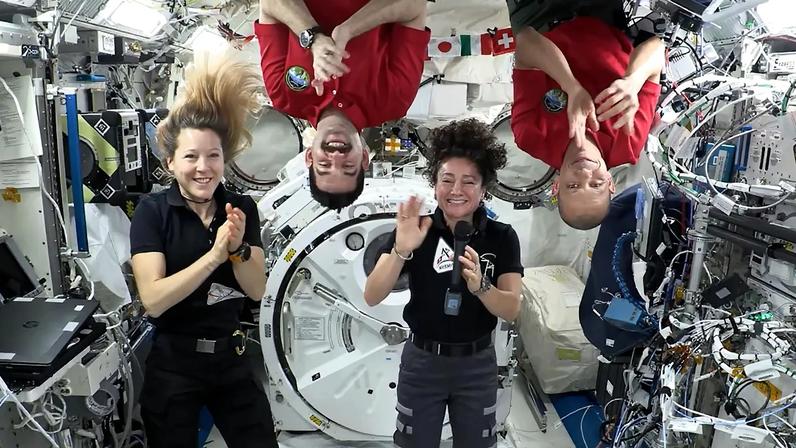 Expedition 74 crew members (from left) Sophie Adenot, Jack Hathaway, Jessica Meir, and Chris Williams congratulate the Artemis III crew in a recorded video message.