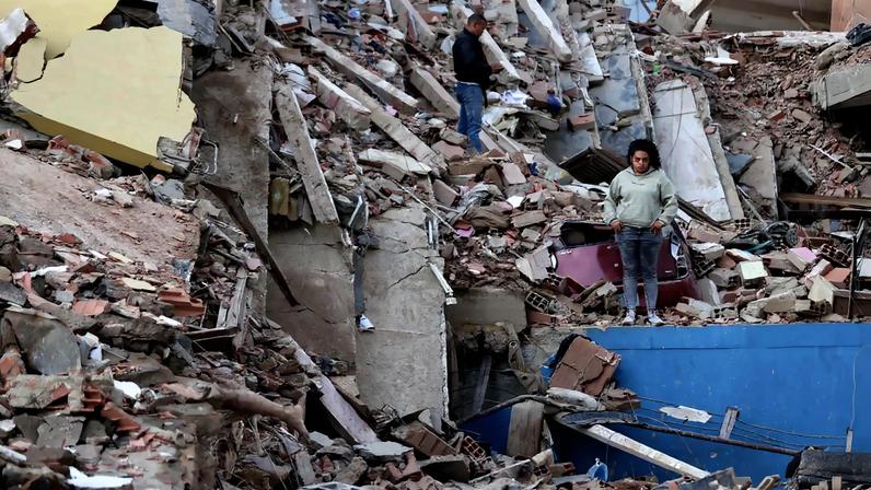 Moradores caminham entre os escombros de prédios que desabaram devido aos terremotos, na cidade de Catia La Mar, no estado costeiro de La Guaira (Venezuela) (Foto: EFE/ Ronald Pena R.)