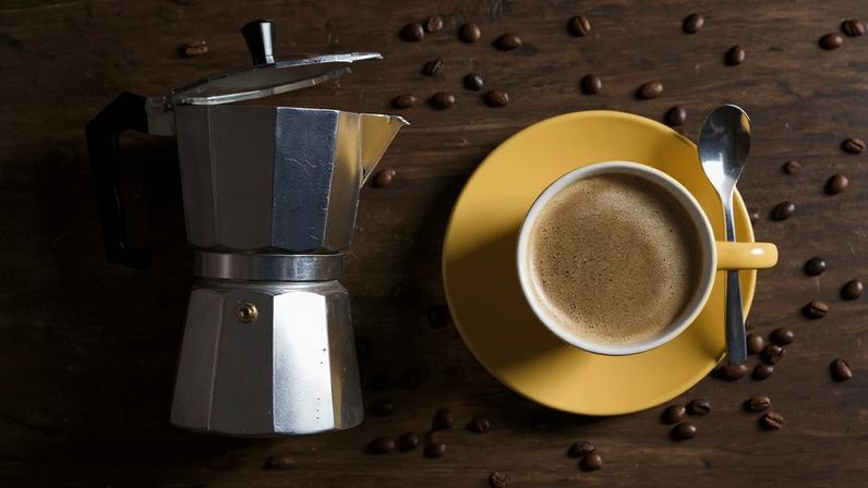 Foto colorida de cafeteira italiana e grãos de café