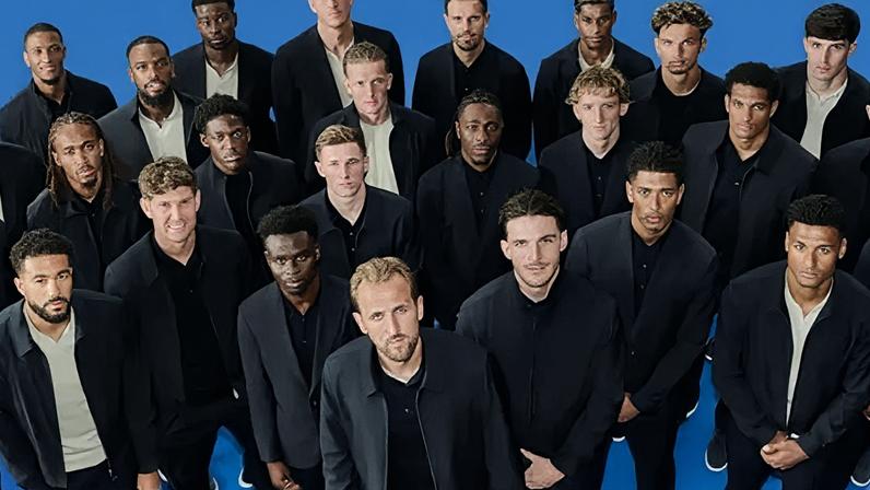Marks & Spencer England men's squad wearing dark jackets and trousers, standing with their arms folded in front of them