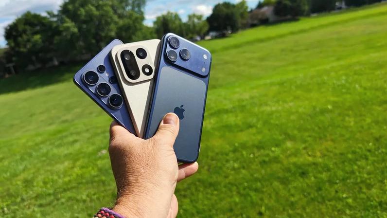Man holding three phones.