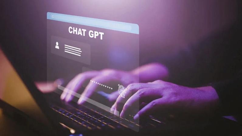 homem teclando em um notebook, com uma projeção virtual do chat gpt