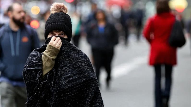Pedestres se protegem do frio na região da Avenida Paulista, em São Paulo.