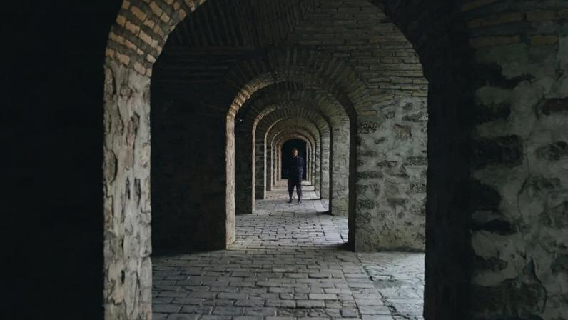 A hallway of stone arches.