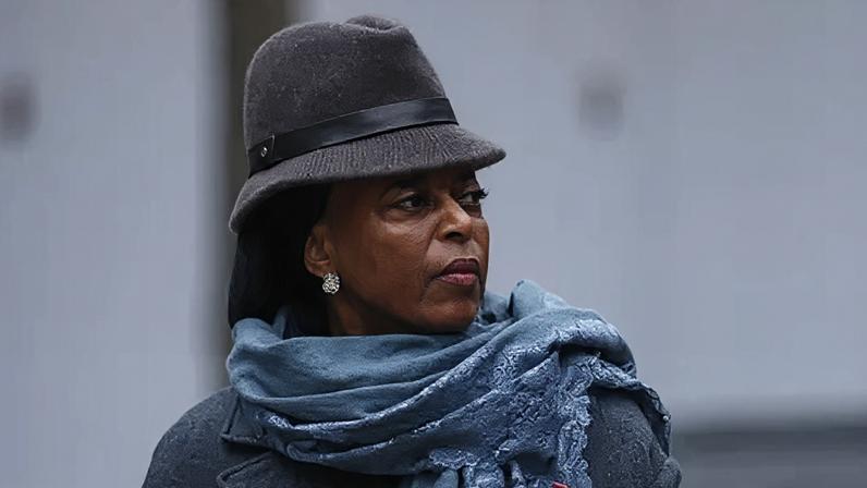 Getty Images Headshot of Diezani Alison-Madueke looking off-camera wearing a grey brimmed hat with a blue scarf and grey coat.