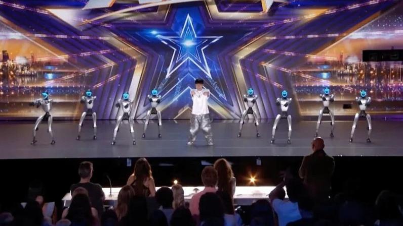 Wu Yufei palco do programa “America’s Got Talent” acompanhado de 8 robôs da empresa Unitree
