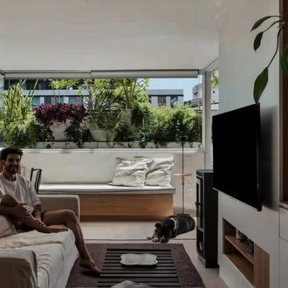Apartamento de 130 m² em SC integra interiores a pátio com muitas plantas