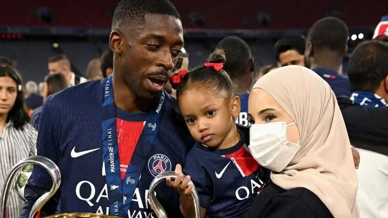 Dembélé e a esposa Rima Edbouche junto com a filha dos dois na conquista da primeira Champions League pelo PSG — Foto: Getty Images